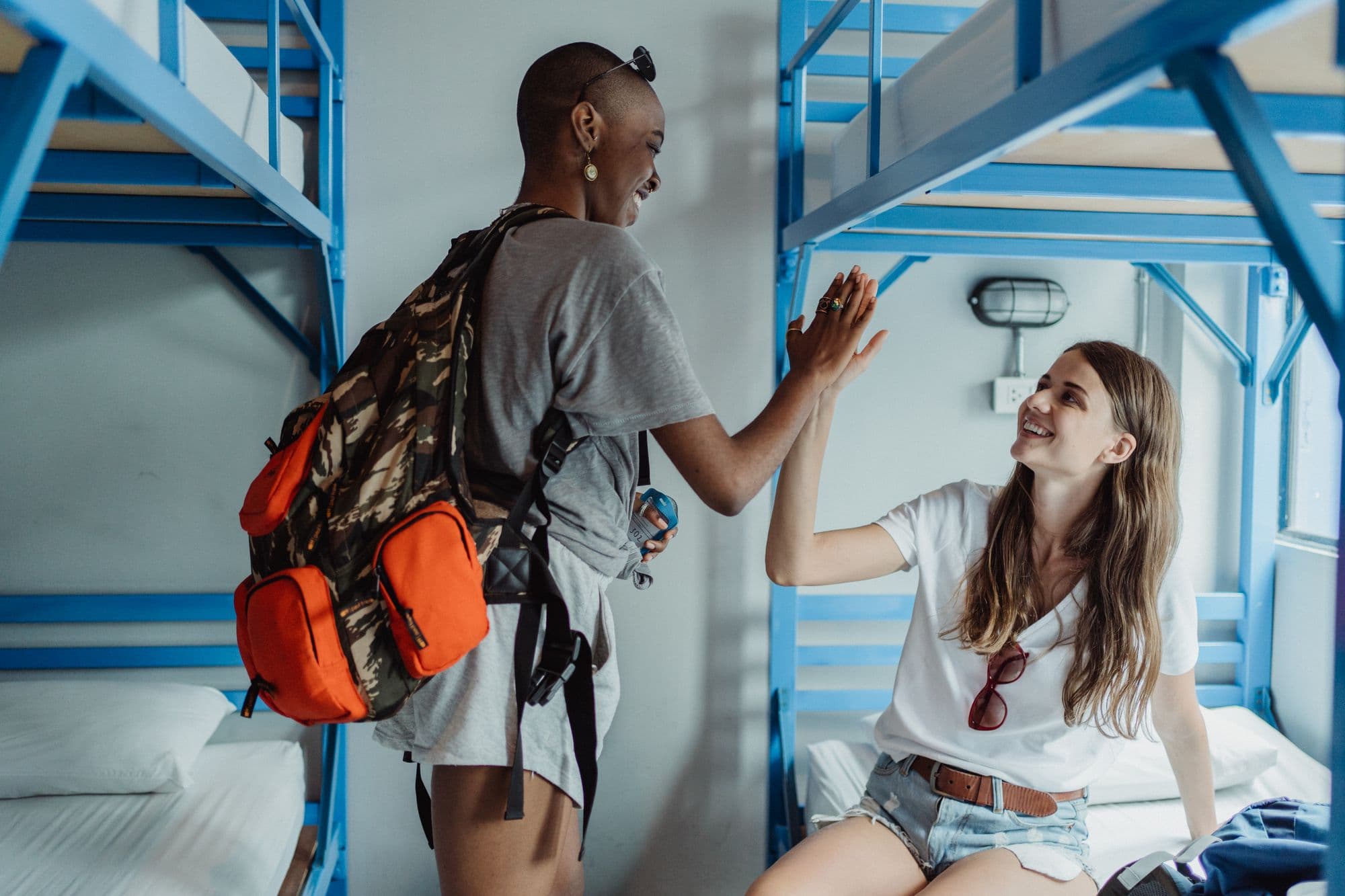 Travellers meeting in a hostel dormitory with bunk beds