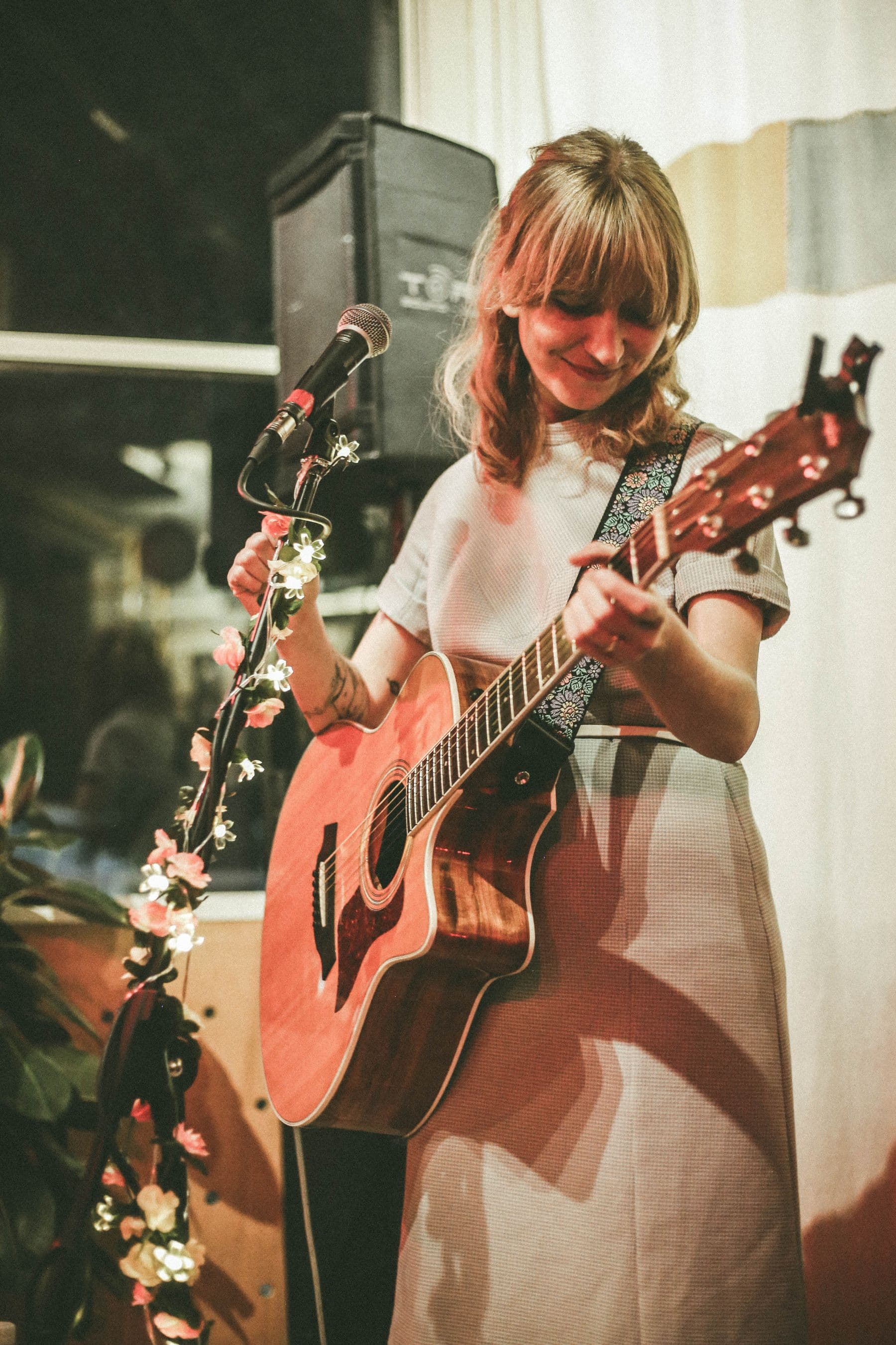Singer and guitarist performing in an intimate indoor venue