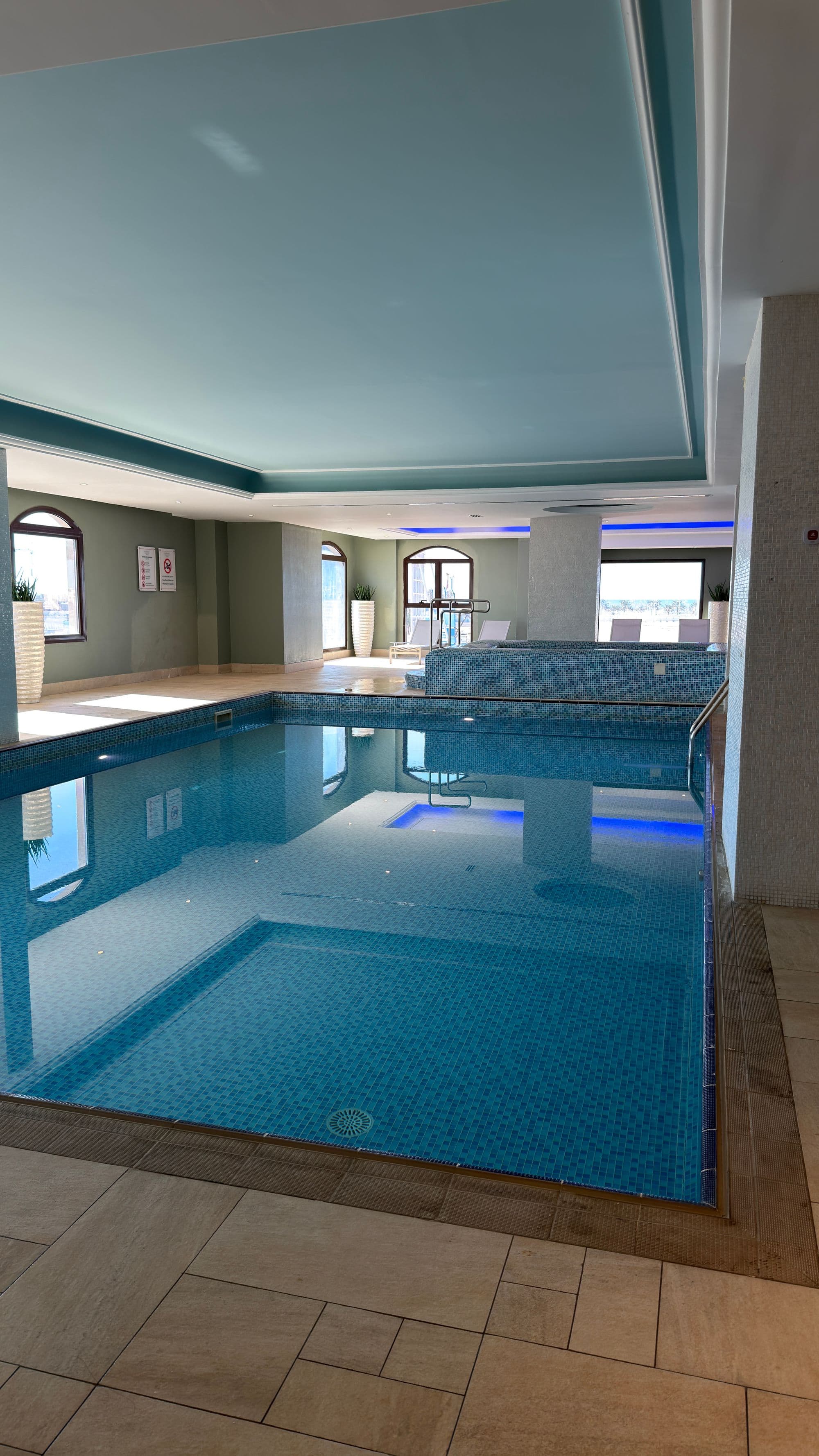 Indoor hotel swimming pool with blue tiles