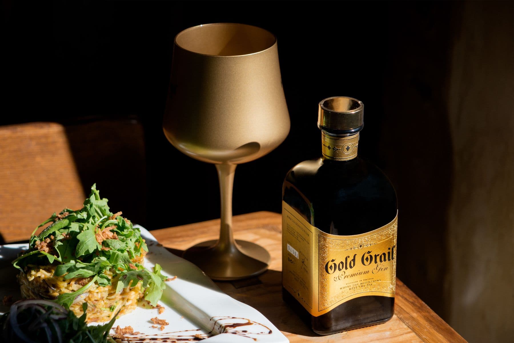 Wine glasses and a bottle arranged on a wooden table