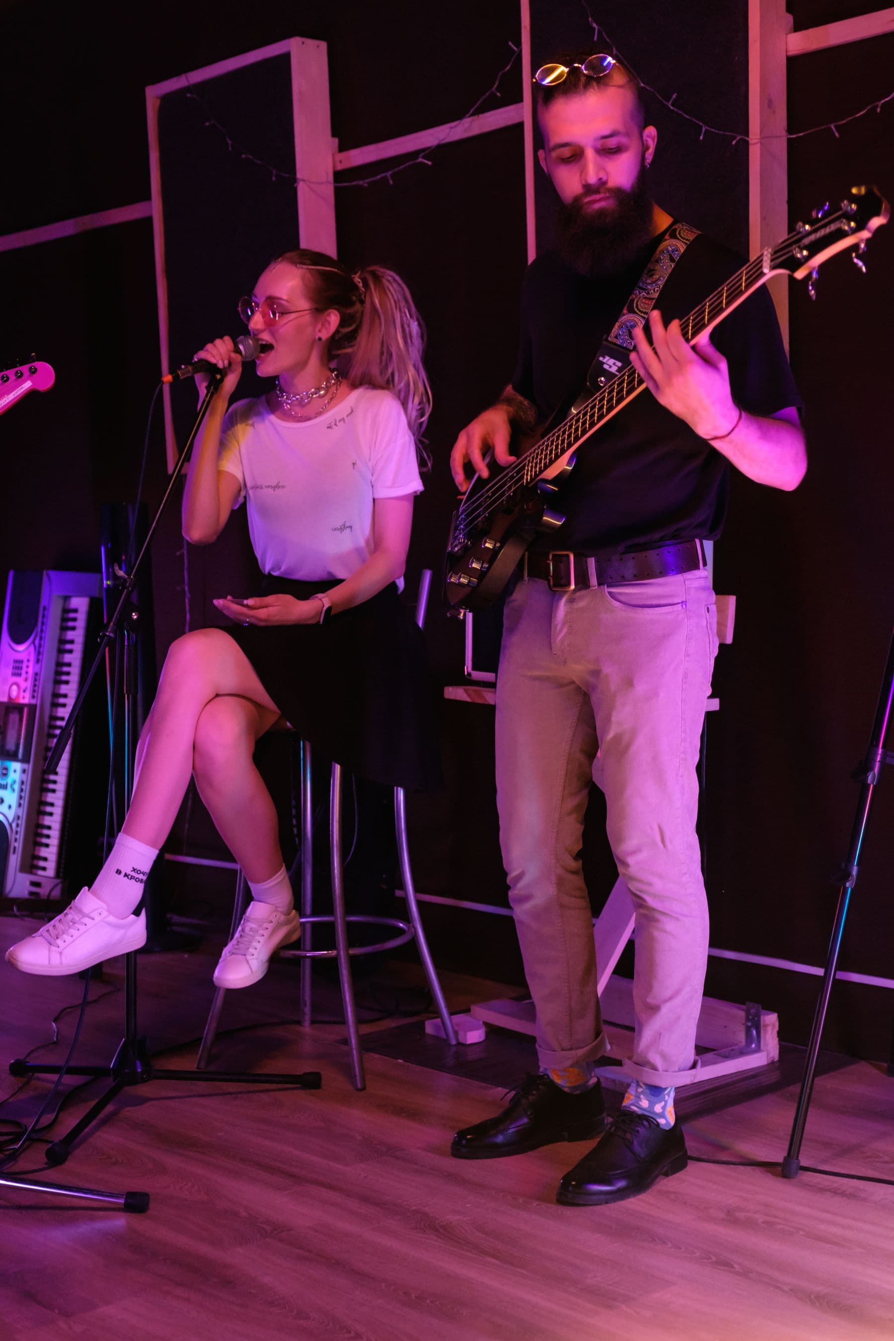 Singer and guitarist performing together in an intimate indoor venue
