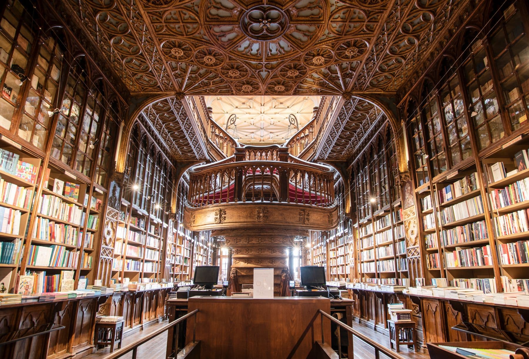 Ornate wooden galleries and books inside Livraria Lello