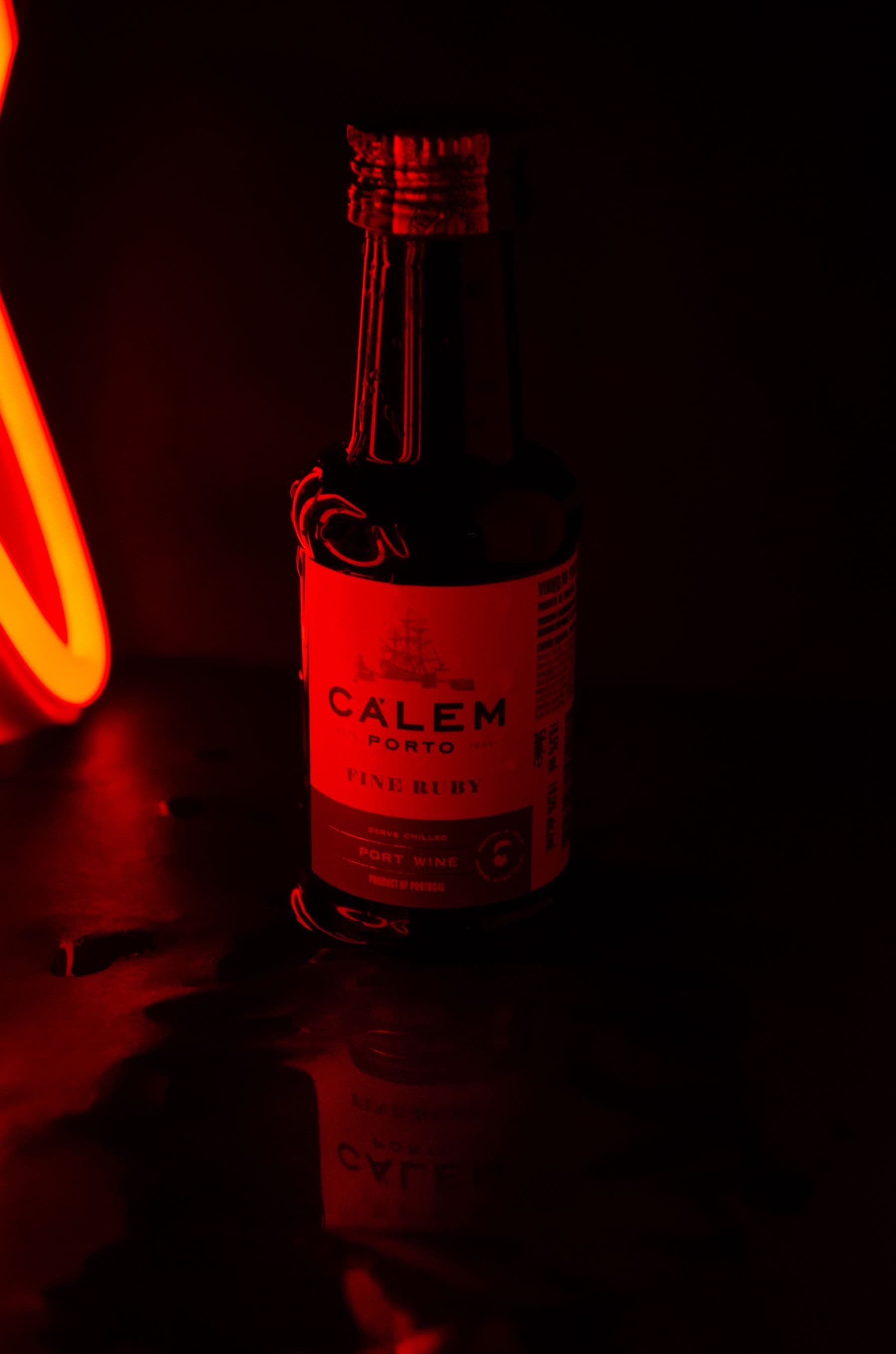 Ruby Port wine bottle illuminated by deep red light
