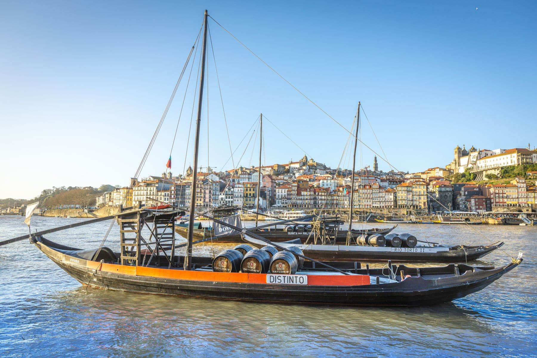Traditional rabelo boats carrying wine barrels on the Douro in Porto