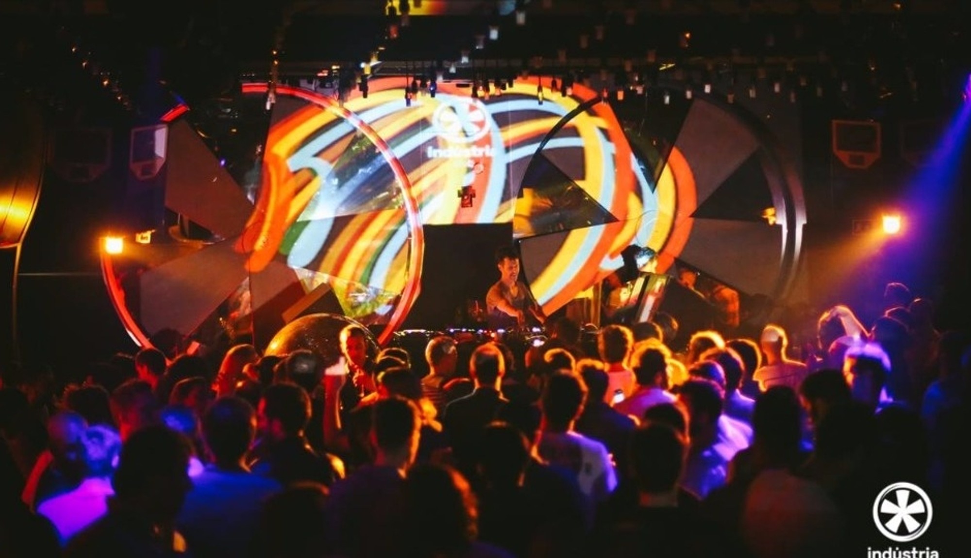 DJ and crowd under colourful projections at Indústria Club Porto