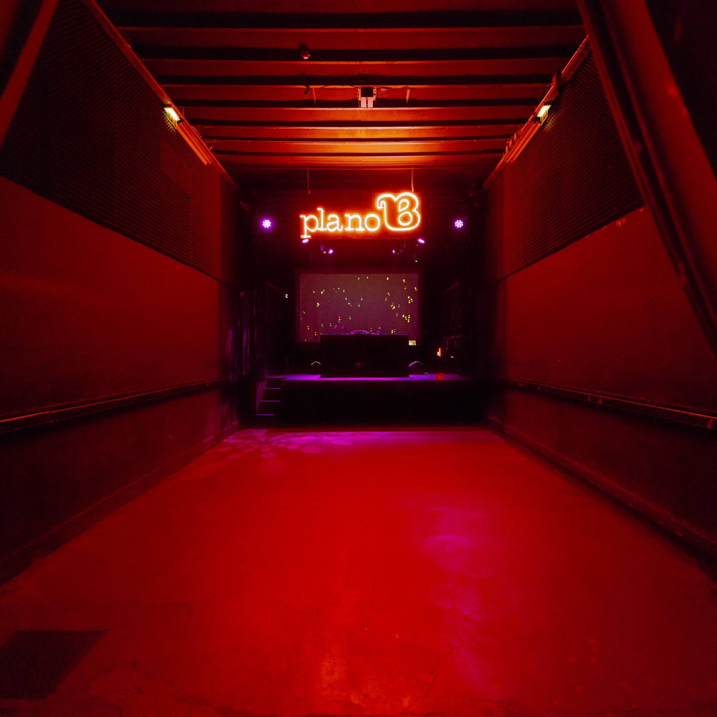 Red-lit corridor and dancefloor at Plano B Porto
